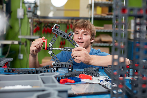 A teenage boy works with a Sphero Blueprint Build Engineering Kits in a classroom.