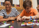 Teacher working with young student on littleBits project.